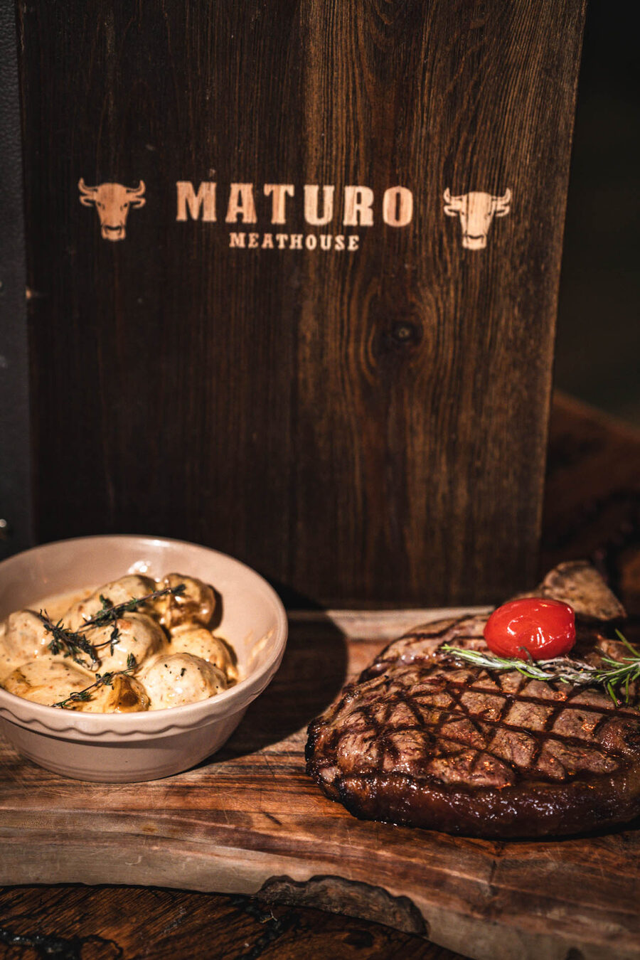 Candlelit dining table with steaks and wine at a Maturo venue