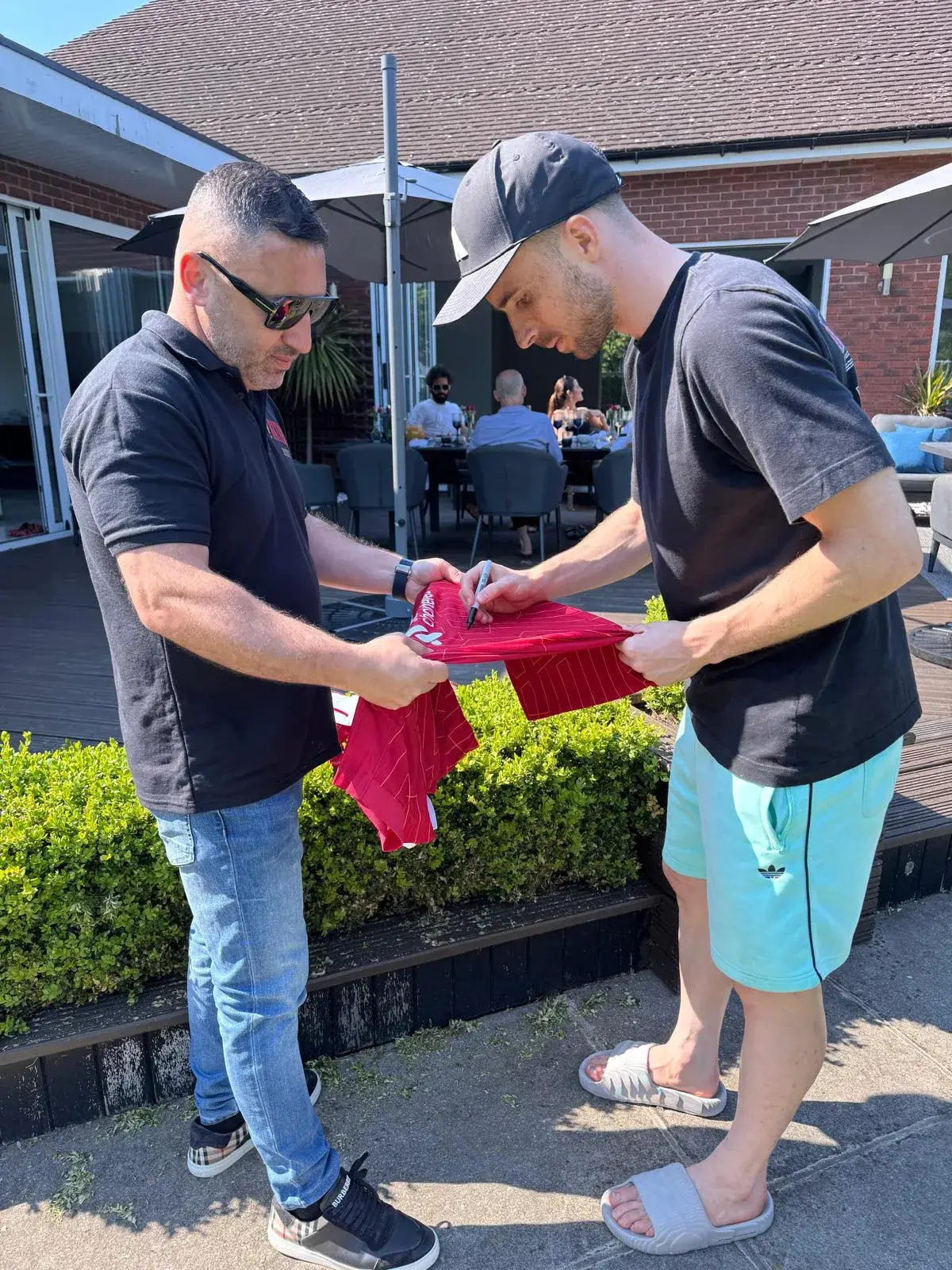A guest signing a football shirt at a private Okan Events gathering
